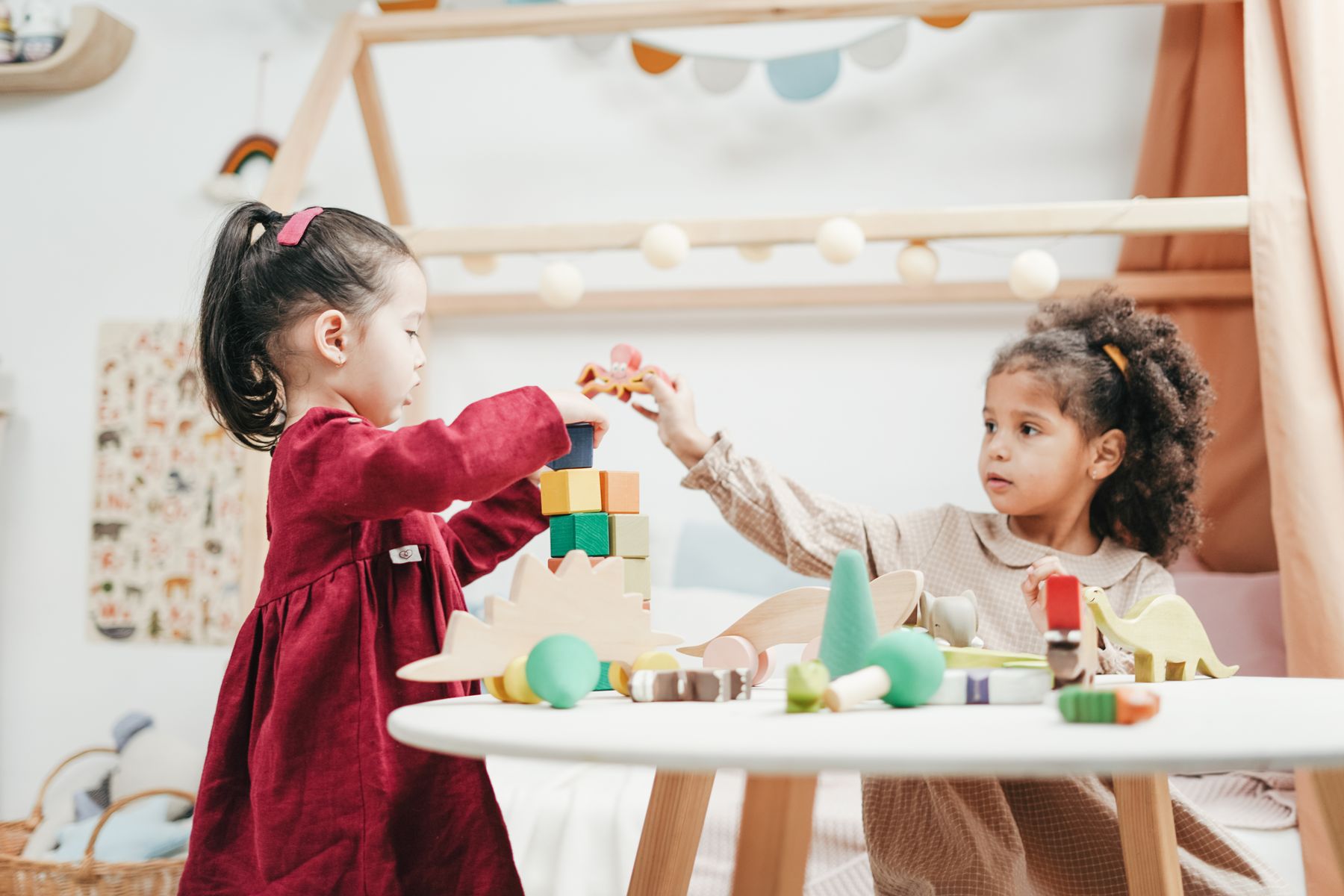 Children playing with wooden toys in a bright indoor play venue